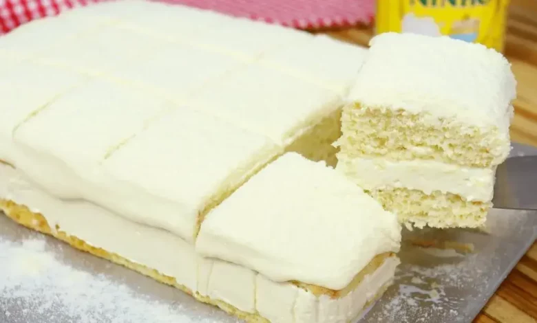 Receita de Bolo de Leite Ninho Molhado cortado em 3 pedaços e cima de uma mesa rustica de madeira