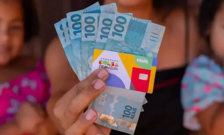 "Caixa Paga Bolsa Família" - Pessoa segurando vários reais de 100 em destaque, com crianças ao fundo sorrindo, simbolizando economia ou ganhos financeiros familiares.