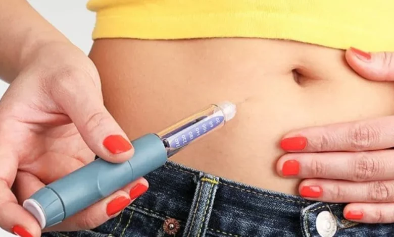 Mulher segurando uma Canetas Emagrecedoras próximo à barriga,