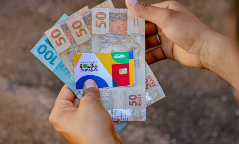 cartão bolsa familia e dinheiro na mão - calendário de pagamento do Bolsa Família de dezembro 2025