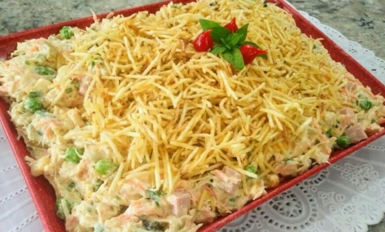 receita de salpicão de frango cremoso no prato vermelho em cima de uma mesa forrada com toalha branca!