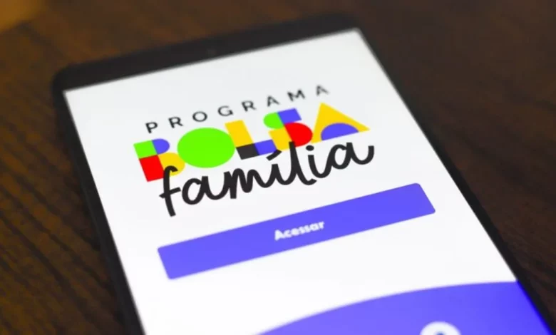 Aplicativo do Programa Família Colorida no celular com fundo de mesa de madeira, promovendo inclusão social e atividades em família.