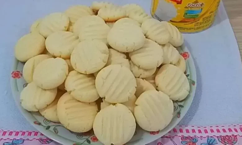 Prato de biscoito amanteigado caseiro no centro, com embalagem de farinha ao fundo, ideal para receitas de biscoitos caseiros.