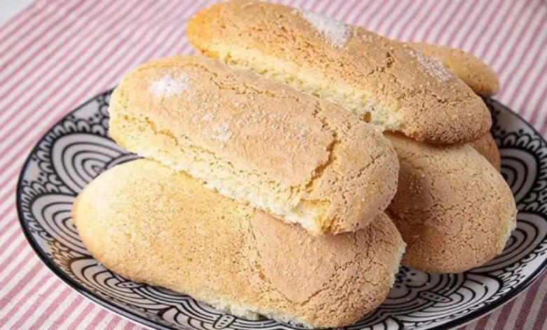 Biscoito Champagne Caseiro servido em um prato com detalhes em cima de uma mesa com toalha de estampa vermelha!