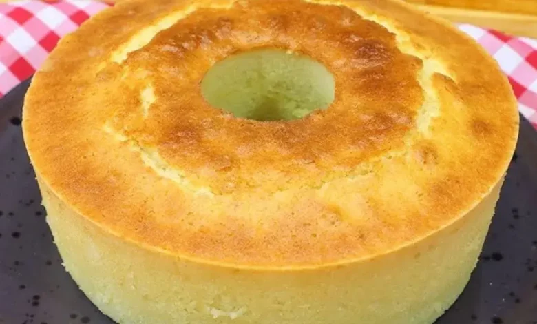 Bolo de Liquidificador, servido em prato preto com fundo de toalha xadrez vermelha e branca, perfeito para café da manhã ou lanches.