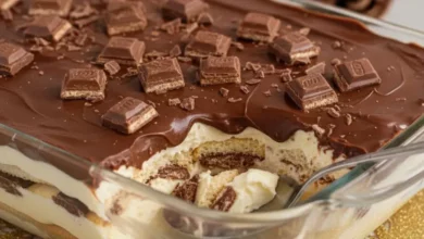 Uma fotografia de alta qualidade de um deliciosa receita de pavê de Bis servido em um refratário de vidro elegante. O pavê deve mostrar camadas bem definidas de creme suave, biscoitos e pedaços generosos de chocolate Bis. A cobertura deve ser uma ganache de chocolate brilhante, com alguns pedaços de Bis inteiros ou triturados por cima para decorar. Foco em close-up, com uma colher inserida suavemente no pavê, sugerindo a textura cremosa. O fundo deve ser levemente desfocado, com um toque de decoração natalina sutil (talvez um pisca-pisca suave ou ramos verdes) para indicar a temática de fim de ano. Iluminação quente e convidativa, cores ricas e contrastantes.