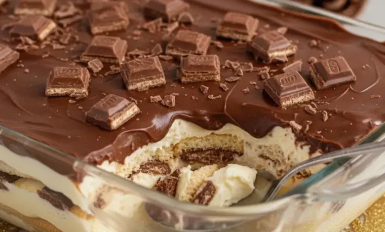 Uma fotografia de alta qualidade de um deliciosa receita de pavê de Bis servido em um refratário de vidro elegante. O pavê deve mostrar camadas bem definidas de creme suave, biscoitos e pedaços generosos de chocolate Bis. A cobertura deve ser uma ganache de chocolate brilhante, com alguns pedaços de Bis inteiros ou triturados por cima para decorar. Foco em close-up, com uma colher inserida suavemente no pavê, sugerindo a textura cremosa. O fundo deve ser levemente desfocado, com um toque de decoração natalina sutil (talvez um pisca-pisca suave ou ramos verdes) para indicar a temática de fim de ano. Iluminação quente e convidativa, cores ricas e contrastantes.