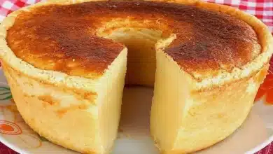 Bolo de Leite Macio e Fofinho de Liquidificador servido em um prato branco e embaixo uma toalha xadrez vermelha