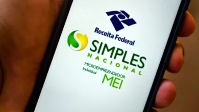 Pessoa segurando smartphone exibindo a opção 'Receita Federal Simples Nacional MEI', importante para declaração de imposto de renda no Brasil.