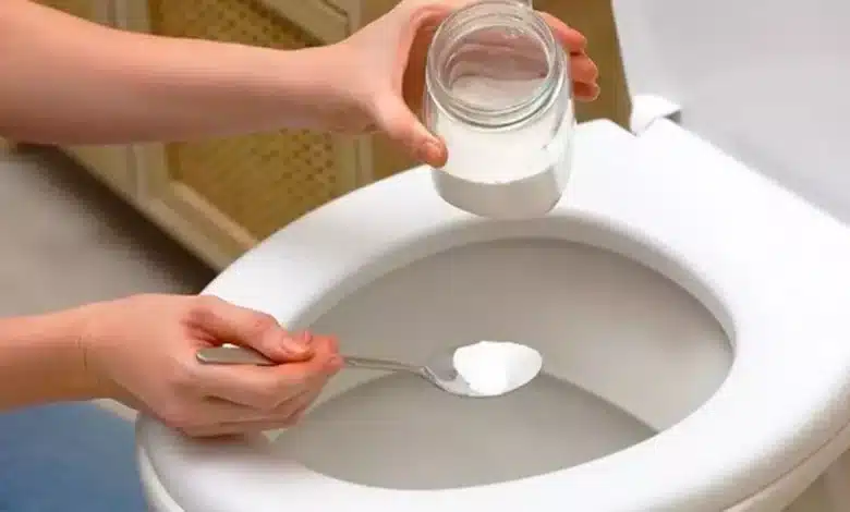 Pessoas colocando Sal no Vaso Sanitário, com uma colher e um pote de vidro, em um banheiro