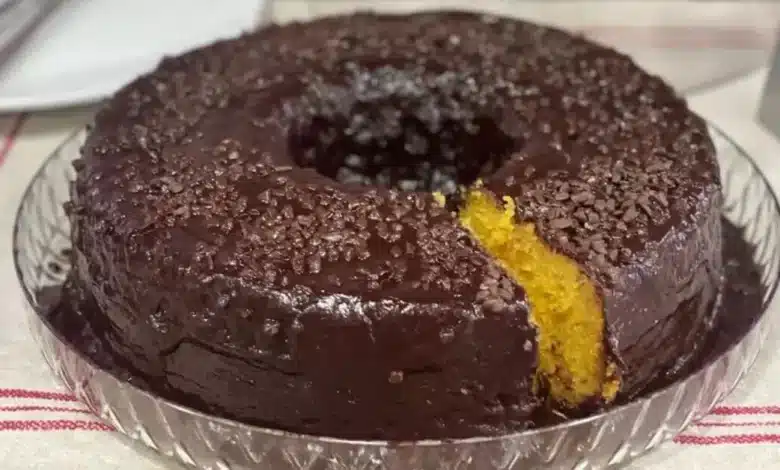 Bolo de Cenoura de Liquidificador com cobertura de chocolate e granulado em cima em uma travessa de vidro