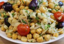 Salada de grão-de-bico com bacalhau servida em prato branco