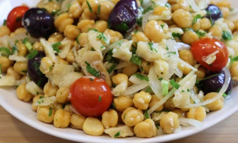 Salada de grão-de-bico com bacalhau servida em prato branco