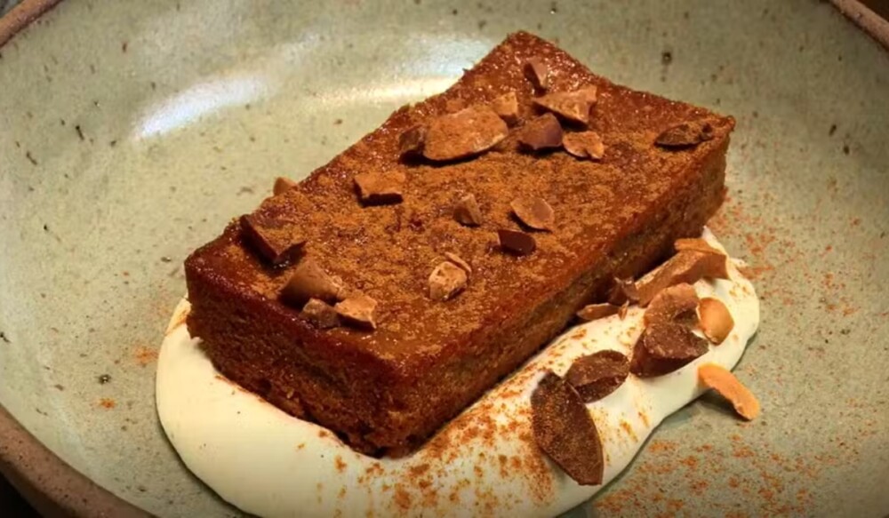 Doce de leite assado com crocante de baru dourado servido em prato rústico