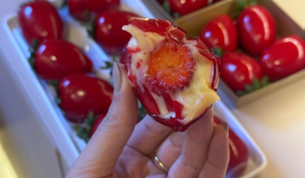 Morango do amor coberto com calda vermelha brilhante.