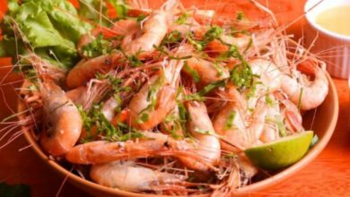 Receita de Camarão no Bafo servido no prato com limão cortado em cima.