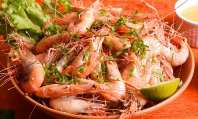 Receita de Camarão no Bafo servido no prato com limão cortado em cima.