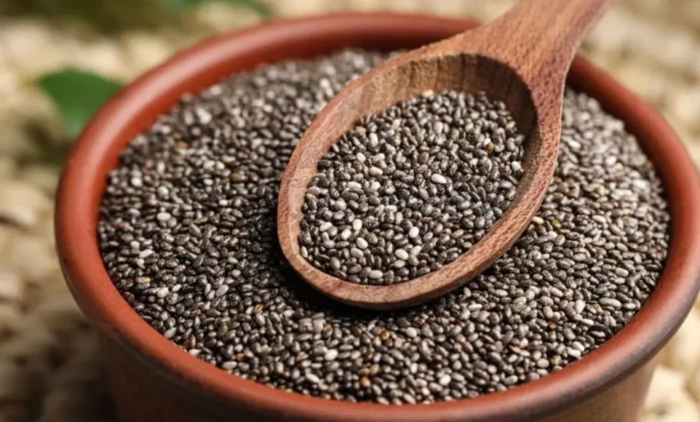 Imagem de semente de chia em uma tigela de barro com uma colher de madeira, destacando o consumo de sementes de chia para uma alimentação saudável.