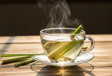 Xícara de chá de capim-limão fumegante sobre mesa de madeira, destacando os benefícios naturais da erva para relaxamento