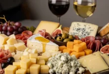 Tábua de queijos para o fim de ano decorada com frutas frescas, nozes e geleias, destacando diferentes texturas e tipos de queijos finos.