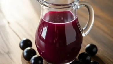 Jarra de suco de jabuticaba roxo intenso e refrescante, rico em antioxidantes, servido com frutas frescas sobre a mesa.