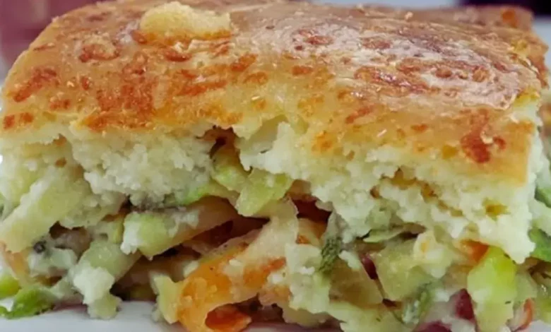 Torta de abobrinha de liquidificador dourada e fofinha servida em uma mesa de café da manhã.